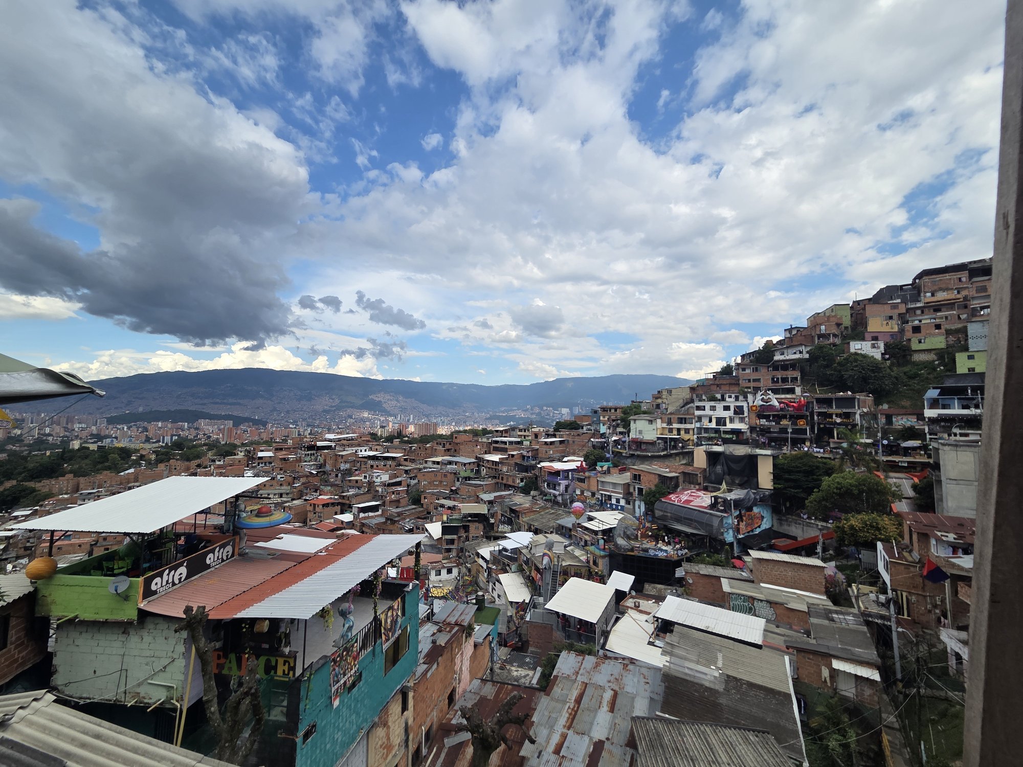 REISIKIRI | Kontrastide linn Medellín. Triiksärgis kelner serveerib lõunat, kõrvaltänaval lebavad narkomaanid